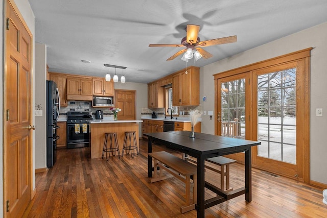 dining area with wood-type flooring, visible vents, baseboards, and ceiling fan