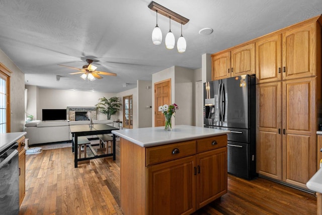 kitchen featuring fridge with ice dispenser, dark wood-style flooring, a center island, ceiling fan, and stainless steel dishwasher