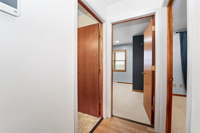 hallway featuring light wood-style floors and baseboards
