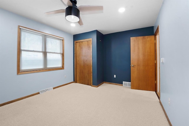 unfurnished bedroom with carpet, visible vents, a closet, and baseboards