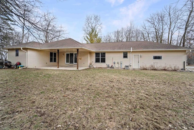 back of property with a patio area and a lawn