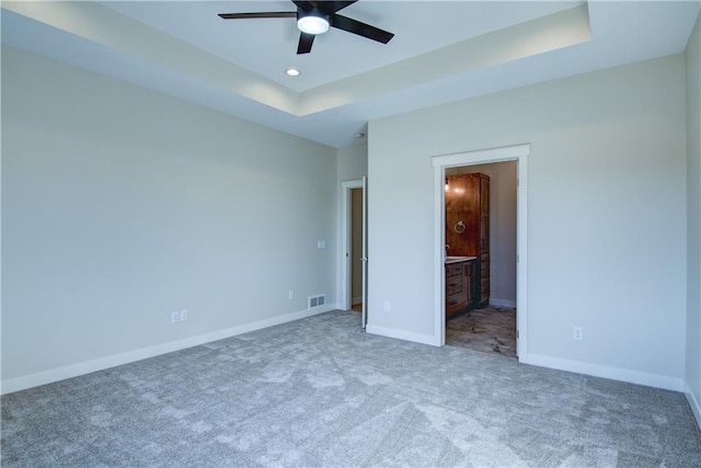 E5215 Queens Dr, Eleva, WI 54738 - unfurnished bedroom featuring carpet floors, a raised ceiling, baseboards, recessed lighting, and connected bathroom