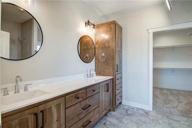 E5215 Queens Dr, Eleva, WI 54738 - bathroom with double vanity, baseboards, and a spacious closet
