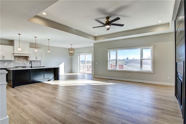E5215 Queens Dr, Eleva, WI 54738 - kitchen featuring a raised ceiling, a ceiling fan, open floor plan, recessed lighting, and light wood-style flooring