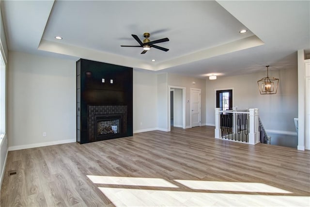 E5215 Queens Dr, Eleva, WI 54738 - unfurnished living room with a tray ceiling, ceiling fan, light wood finished floors, and recessed lighting