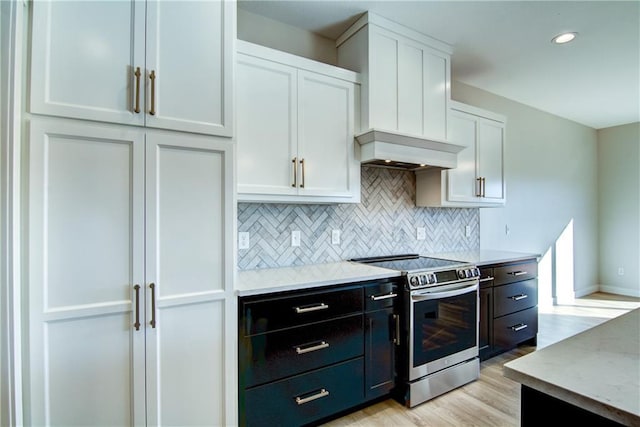 E5215 Queens Dr, Eleva, WI 54738 - kitchen with stainless steel range with electric cooktop, white cabinetry, backsplash, light wood-style floors, and baseboards