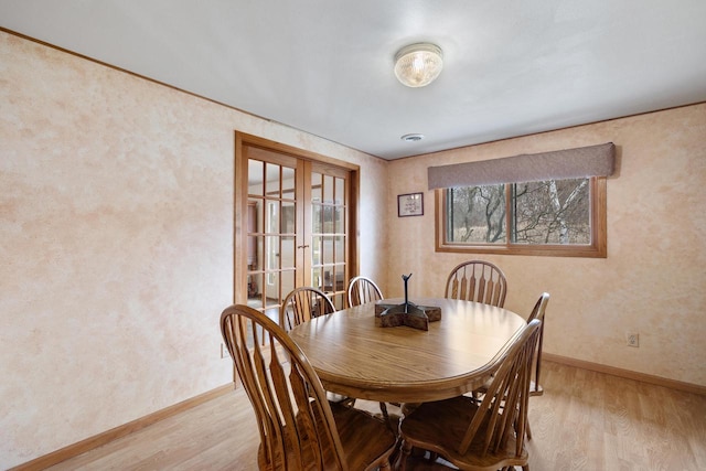 dining area with light wood-style floors and baseboards