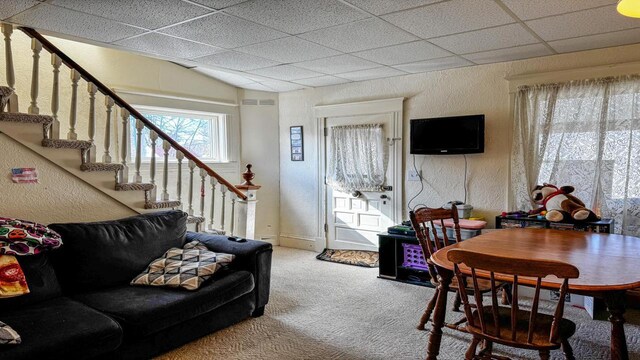 816 Royalton St, Waupaca, WI 54981 - living area with a paneled ceiling, carpet flooring, a textured wall, and stairway
