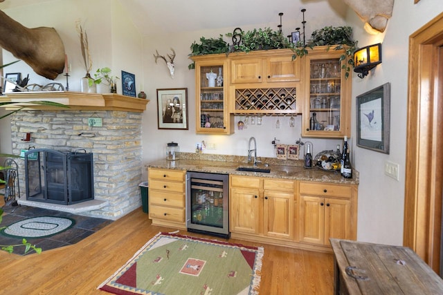 W340S2401 County Road C, Oconomowoc, WI 53066 - bar featuring indoor wet bar, a sink, a stone fireplace, light wood-style floors, and wine cooler