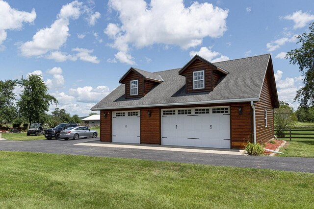 W340S2401 County Road C, Oconomowoc, WI 53066 - view of front of home featuring a detached garage, a front yard, fence, faux log siding, and a shingled roof