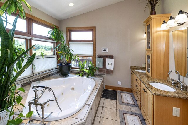 W340S2401 County Road C, Oconomowoc, WI 53066 - bathroom with a tub with jets, a sink, lofted ceiling, double vanity, and baseboards