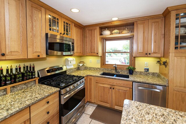 W340S2401 County Road C, Oconomowoc, WI 53066 - kitchen with light tile patterned floors, glass insert cabinets, light stone countertops, a sink, and stainless steel appliances