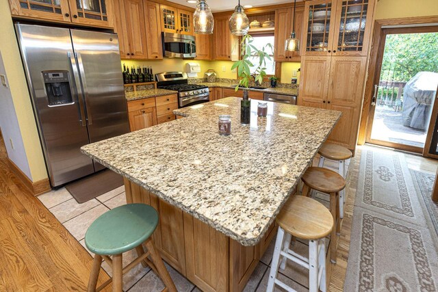 W340S2401 County Road C, Oconomowoc, WI 53066 - kitchen featuring brown cabinets, a breakfast bar, plenty of natural light, and stainless steel appliances