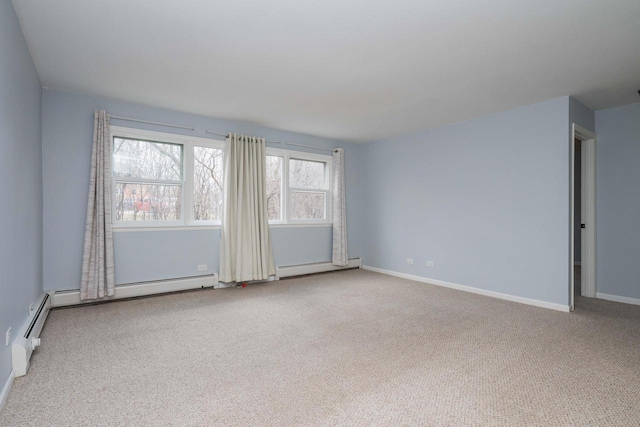 spare room with carpet, baseboard heating, and baseboards