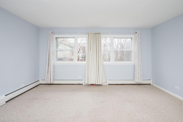 unfurnished room featuring a baseboard heating unit, baseboards, and carpet floors