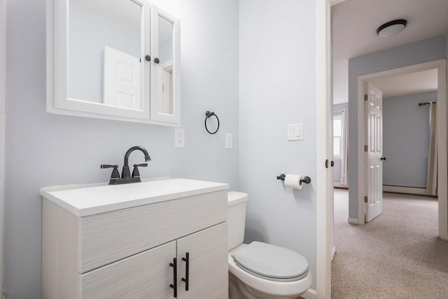 bathroom featuring toilet, vanity, and baseboards