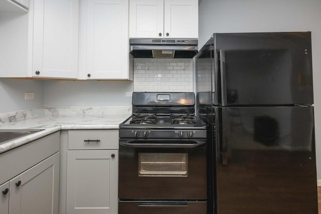 kitchen featuring white cabinets, under cabinet range hood, black appliances, and decorative backsplash
