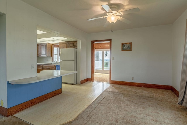 N1616 Haddinger Rd, Monroe, WI 53566 - kitchen with freestanding refrigerator, a ceiling fan, light countertops, brown cabinets, and a peninsula