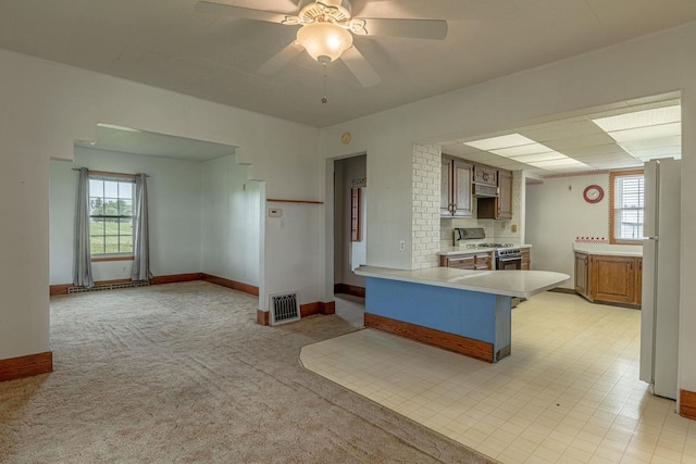 N1616 Haddinger Rd, Monroe, WI 53566 - kitchen featuring range with gas cooktop, light countertops, healthy amount of natural light, and freestanding refrigerator