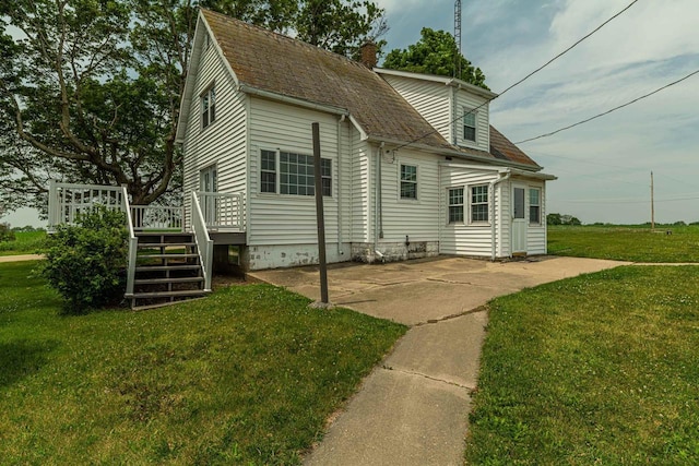 N1616 Haddinger Rd, Monroe, WI 53566 - back of property featuring a lawn, a deck, a chimney, and roof with shingles