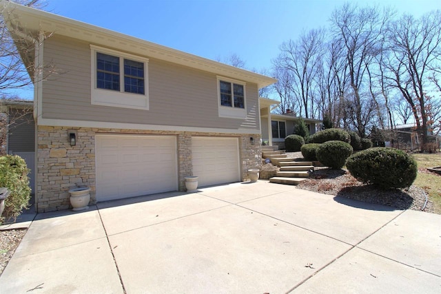 4786 Cardinal Ln, Sun Prairie, WI 53590 - view of side of property with stone siding, an attached garage, and driveway
