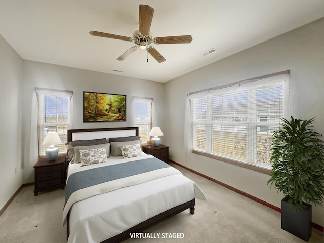 bedroom featuring visible vents, baseboards, ceiling fan, and light carpet