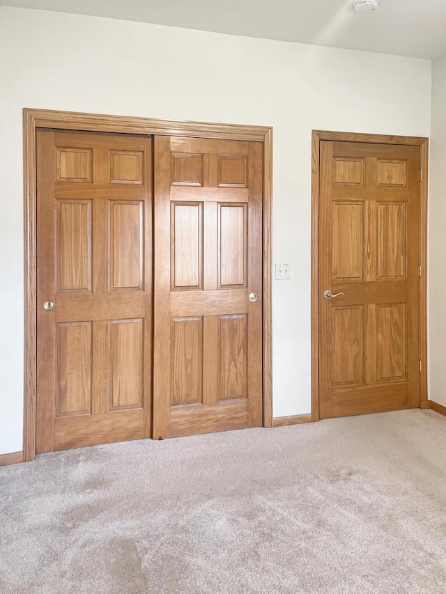 unfurnished bedroom with baseboards and carpet