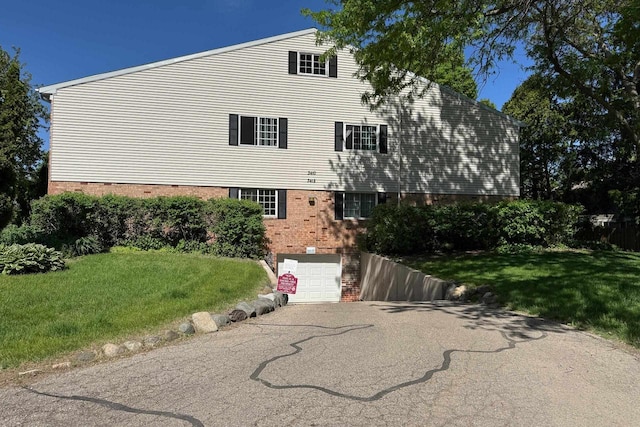 3410 Valley Ridge Rd Unit 1, Middleton, WI 53562 - view of home's exterior with asphalt driveway, a garage, a lawn, and brick siding