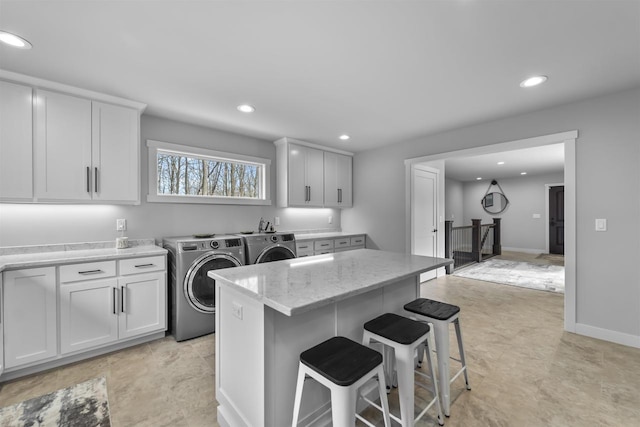 W7181 Duck Creek Ave, Westfield, WI 53964 - kitchen featuring separate washer and dryer, recessed lighting, a kitchen breakfast bar, and light stone countertops