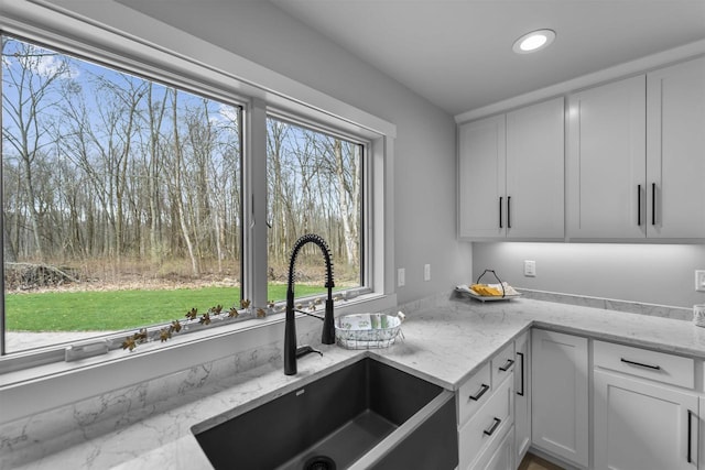 W7181 Duck Creek Ave, Westfield, WI 53964 - kitchen with a sink, white cabinetry, a wealth of natural light, and light stone countertops