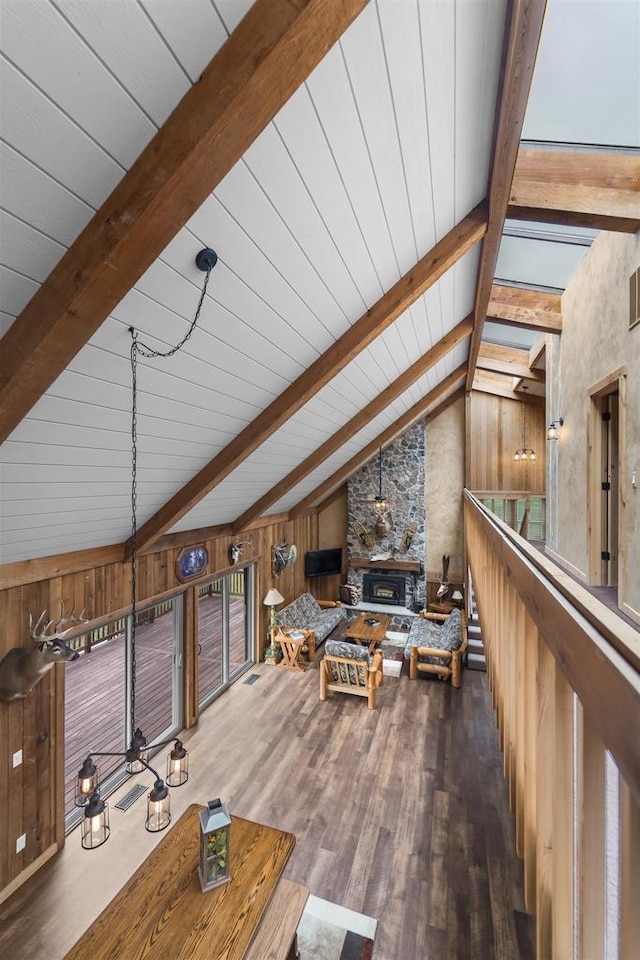 W7181 Duck Creek Ave, Westfield, WI 53964 - living area featuring a stone fireplace, lofted ceiling with beams, wood finished floors, and wooden walls