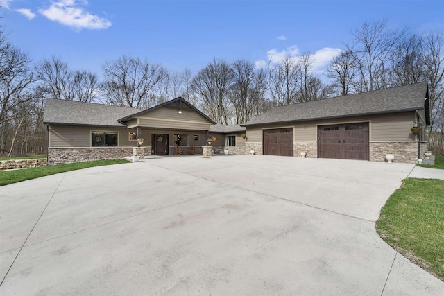 W7181 Duck Creek Ave, Westfield, WI 53964 - view of front of home featuring covered porch, an attached garage, concrete driveway, and stone siding