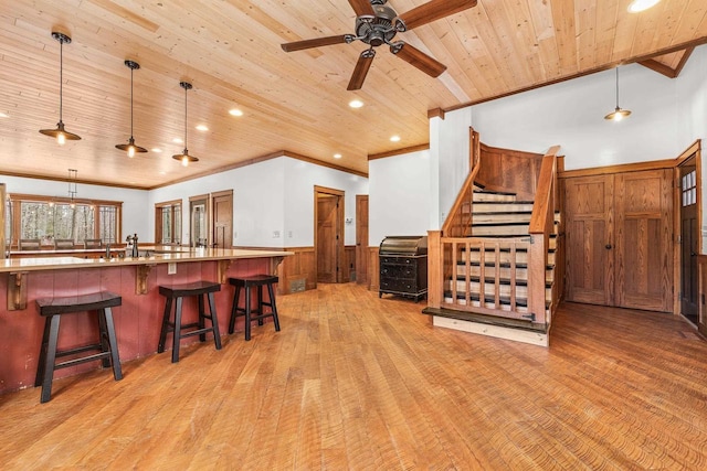 3853 County Rd E, Junction City, WI 54443 - kitchen with wooden ceiling, light wood-style floors, wainscoting, a ceiling fan, and a breakfast bar area
