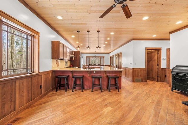 3853 County Rd E, Junction City, WI 54443 - kitchen featuring a wainscoted wall, light wood-style flooring, wood ceiling, a peninsula, and brown cabinets