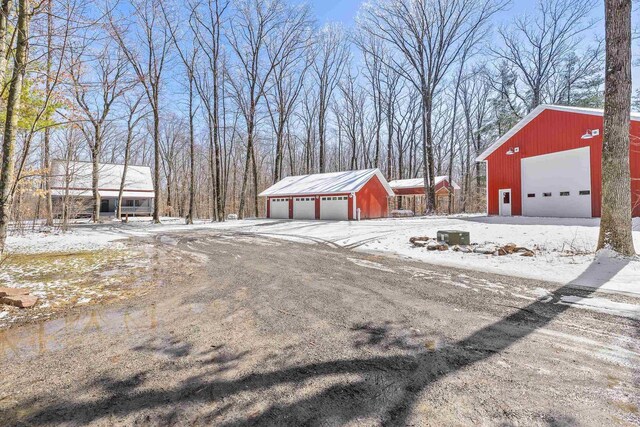 3853 County Rd E, Junction City, WI 54443 - yard layered in snow featuring a garage and an outdoor structure