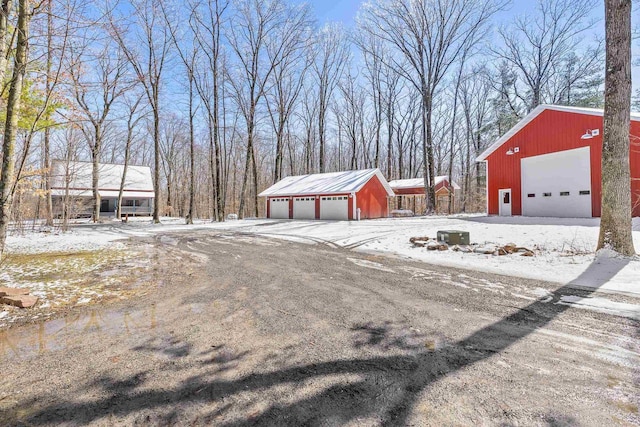 3853 County Rd E, Junction City, WI 54443 - yard layered in snow featuring a garage and an outdoor structure