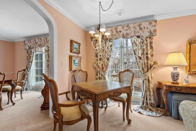 1012 E Kramer Ln, Appleton, WI 54915 - dining area featuring a chandelier, arched walkways, light colored carpet, and crown molding