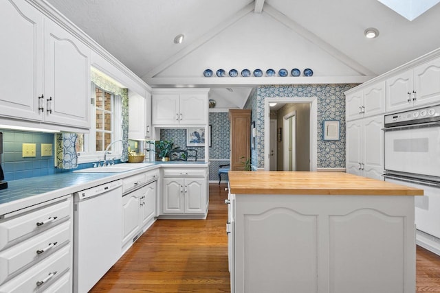 1012 E Kramer Ln, Appleton, WI 54915 - kitchen featuring white appliances, white cabinetry, lofted ceiling with skylight, wallpapered walls, and a kitchen island