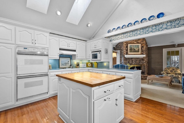 1012 E Kramer Ln, Appleton, WI 54915 - kitchen with white appliances, open floor plan, vaulted ceiling with skylight, wooden counters, and under cabinet range hood