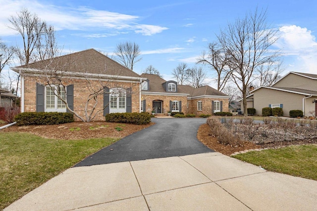 1012 E Kramer Ln, Appleton, WI 54915 - view of front of home featuring brick siding, driveway, a shingled roof, and a front lawn