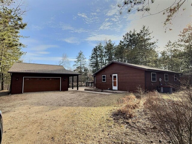 N9378 21st Ave, Neshkoro, WI 54960 - exterior space featuring central air condition unit, a garage, and dirt driveway