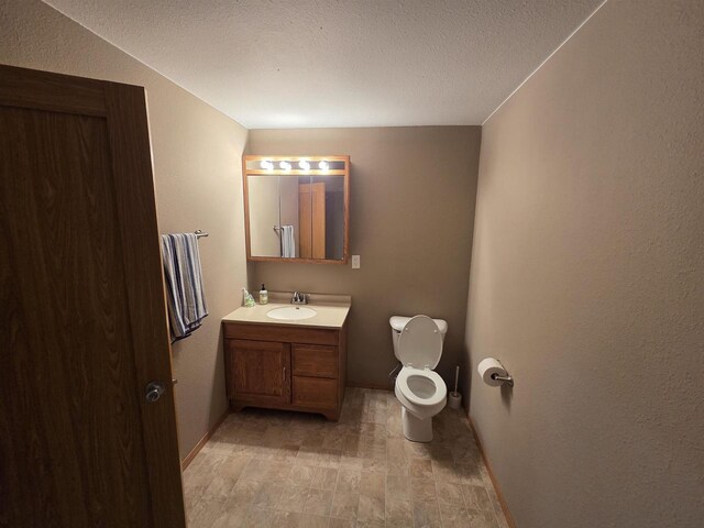 246 Golliher Ct, Westfield, WI 53964 - bathroom with toilet, vanity, baseboards, and a textured ceiling