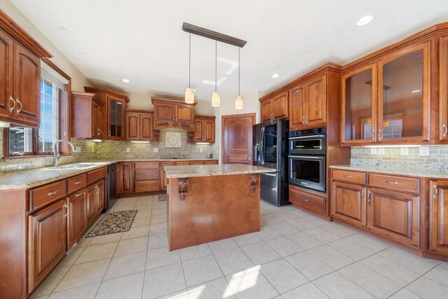 3895 Shorebird Ct, Oshkosh, WI 54904 - kitchen with fridge with ice dispenser, dishwasher, brown cabinetry, and light stone counters