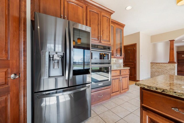 3895 Shorebird Ct, Oshkosh, WI 54904 - kitchen featuring tasteful backsplash, double wall oven, stainless steel fridge, light tile patterned floors, and brown cabinets