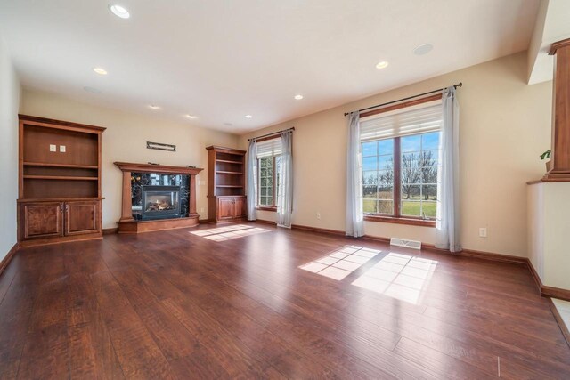 3895 Shorebird Ct, Oshkosh, WI 54904 - unfurnished living room featuring dark wood-style flooring, visible vents, baseboards, and a fireplace