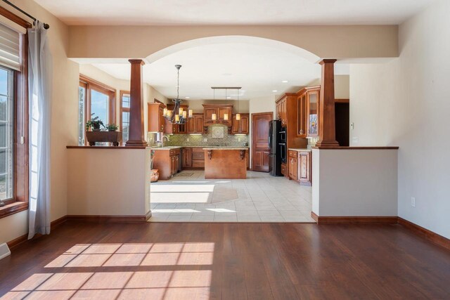 3895 Shorebird Ct, Oshkosh, WI 54904 - kitchen featuring arched walkways, brown cabinets, and decorative columns