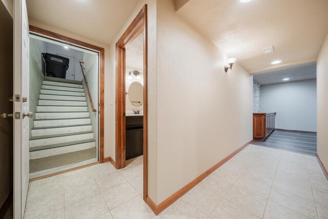 3895 Shorebird Ct, Oshkosh, WI 54904 - corridor featuring light tile patterned floors, recessed lighting, a sink, stairs, and baseboards
