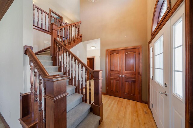 3895 Shorebird Ct, Oshkosh, WI 54904 - foyer with light wood-type flooring, a towering ceiling, and stairs