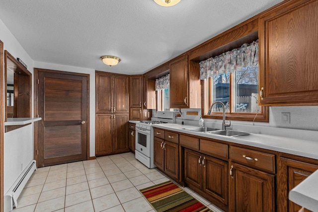 2963 Sunset Point Ln, Oshkosh, WI 54904 - kitchen with white range with gas cooktop, light tile patterned floors, light countertops, a baseboard radiator, and a sink