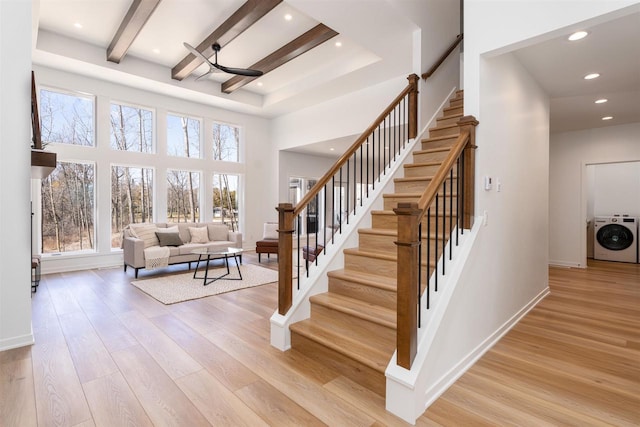 stairs featuring recessed lighting, wood finished floors, washer / dryer, baseboards, and beam ceiling